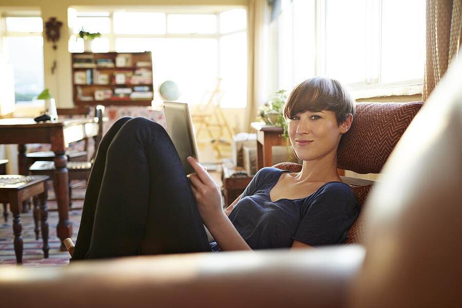 Young woman relaxing at home with tablet #1 Photograph by Klaus Vedfelt