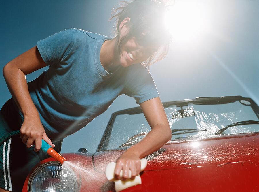 Young woman washing car #1 Photograph by Image Source