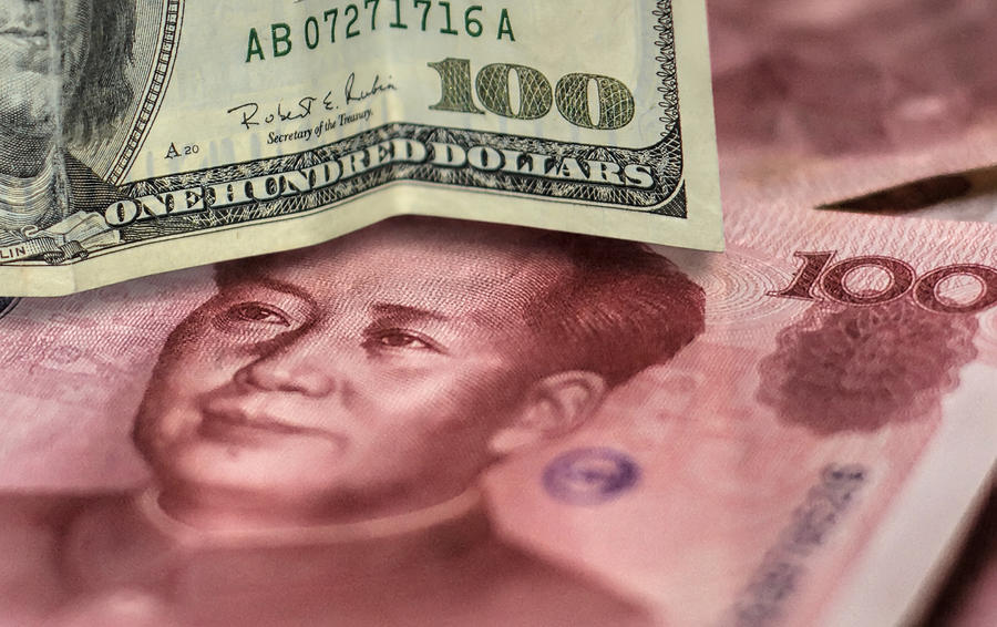 100 US dollar bill and 100 China yuan banknote. Photograph by TheaDesign