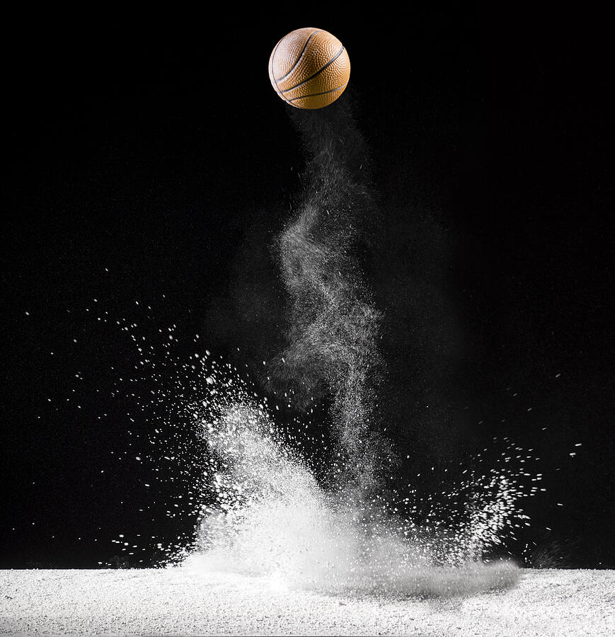 Impact and rebound of a ball of basketball on a surface of land and powder on a black background #17 Photograph by Jose A. Bernat Bacete