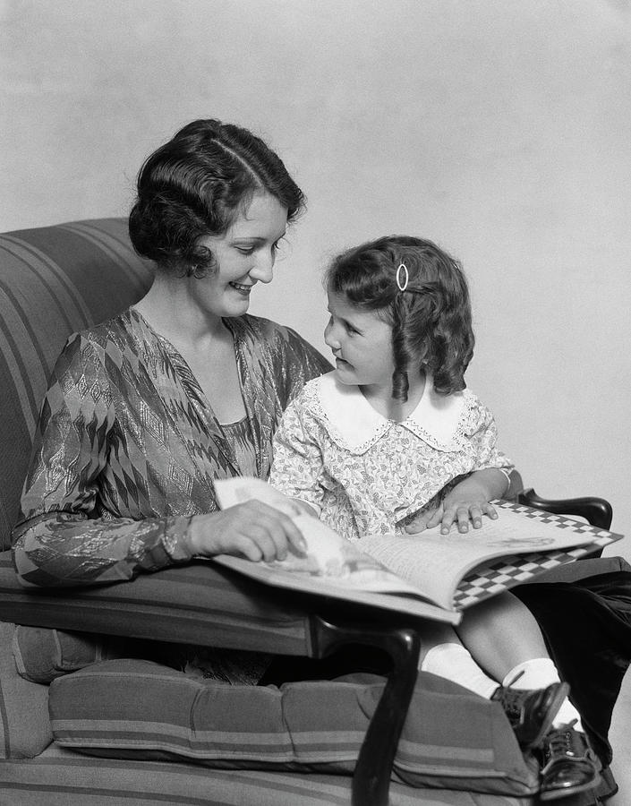 1920s 1930s Mother And Daughter Smiling Sitting In Chair Reading Book ...