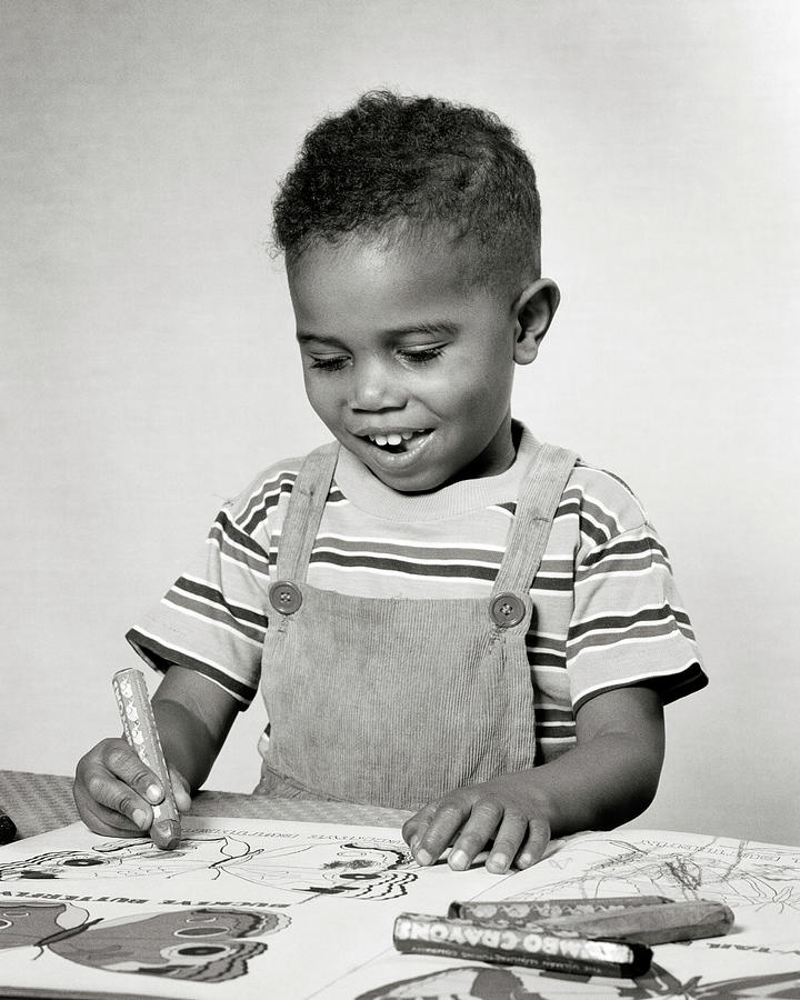 1940s 1950s creative smiling African-American boy toddler sitting at table working drawing Photograph by Panoramic Images