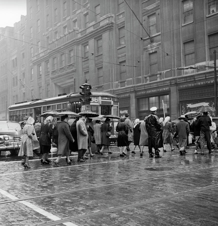 1940s 1950s pedestrian intersection city cross walk umbrellas rain wet ...