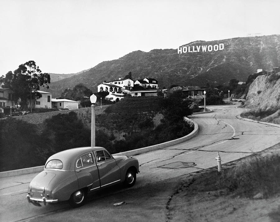 1950s Austin car driving up the Hollywood Hills with Hollywood sign in distance Los Angeles CA USA  Photograph by Panoramic Images
