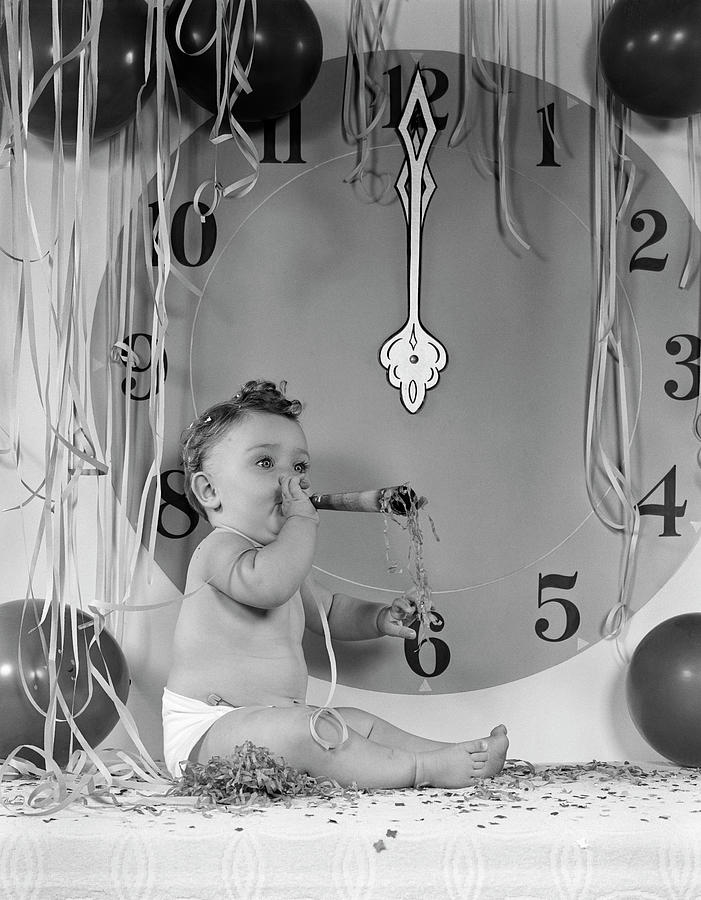 1950s New Year Baby Sitting By Midnight Clock Face Blowing Party Noise Maker Amid Balloons And Paper Photograph by Panoramic Images