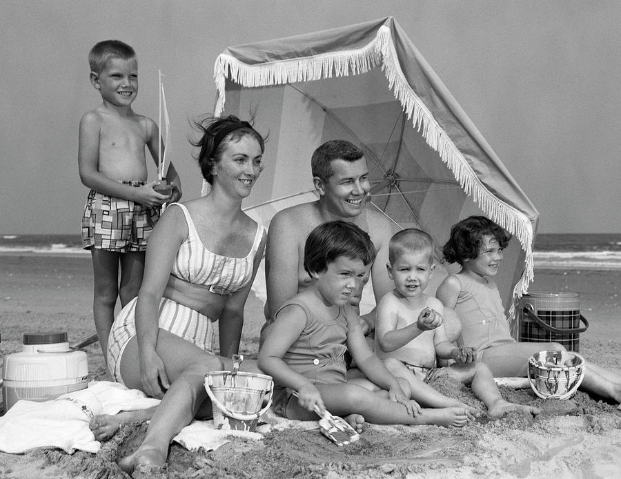 1960s Family Of 6 On Beach Under Umbrella With Pails And Coolers Photograph by Panoramic Images