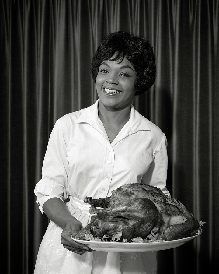 1960s smiling African-American woman holding platter with holiday turkey Photograph by Panoramic Images