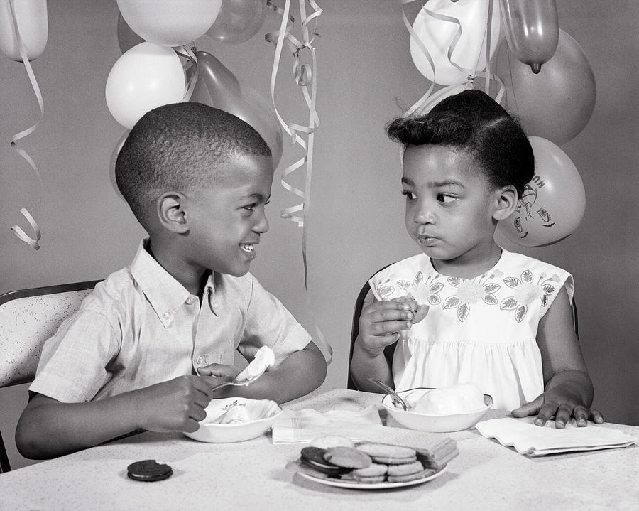 1960s two African American children boy girl brother sister looking at each other eating ice cream Photograph by Panoramic Images