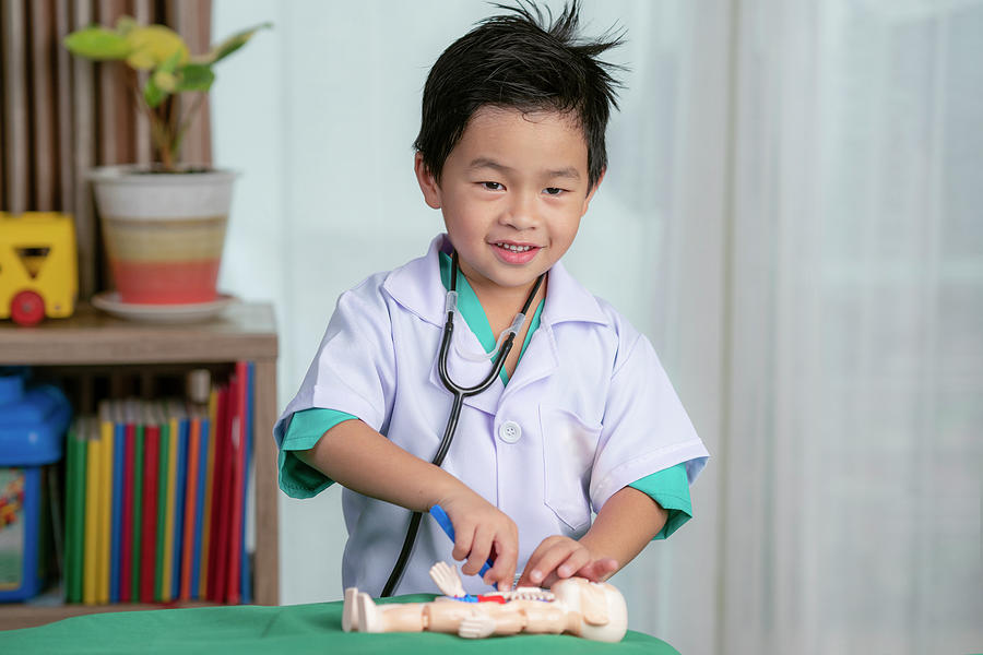 Asian boy play surgery with toy Photograph by Anek Suwannaphoom - Fine ...