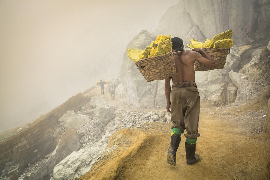 Asian worker carrying baskets of sulfur in Ijen volcano #2 Photograph by Joakimbkk