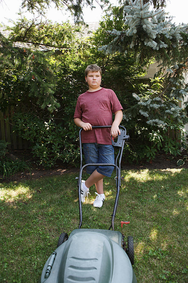 Boy mowing grass with lawnmower #2 Photograph by Image Source