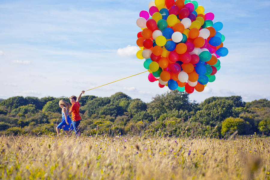 2 Children Running With Bunch Of Balloons Photograph by Howard Kingsnorth