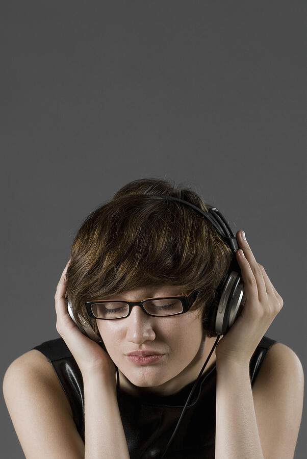 Close-up of a young woman listening to music #2 Photograph by Glowimages