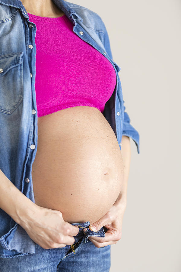 Close up of the big baby bump of a woman trying to close her jeans, Italy #2 Photograph by Giacomo Augugliaro