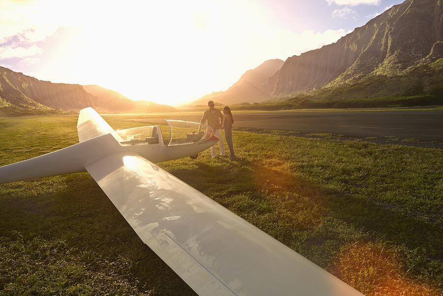 Couple admiring glider airplane on remote runway #2 Photograph by Colin Anderson Productions pty ltd
