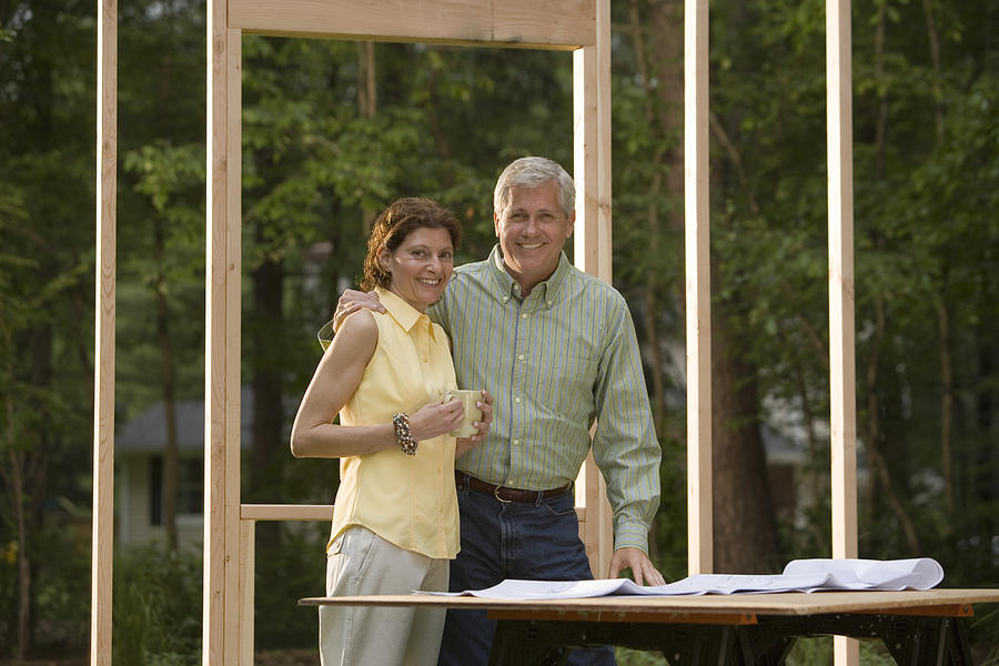 Couple reviewing blueprints at construction site #2 Photograph by Comstock Images