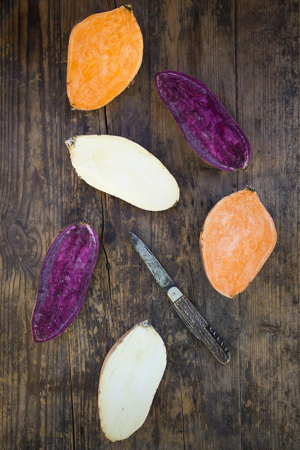 Different Sweet Potatoes On Dark Wood, Cut In Half #2 Photograph by Larissa Veronesi