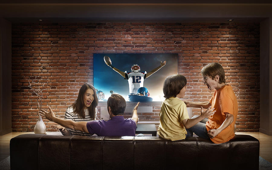 Family with children watching American football game on TV #2 Photograph by Dmytro Aksonov