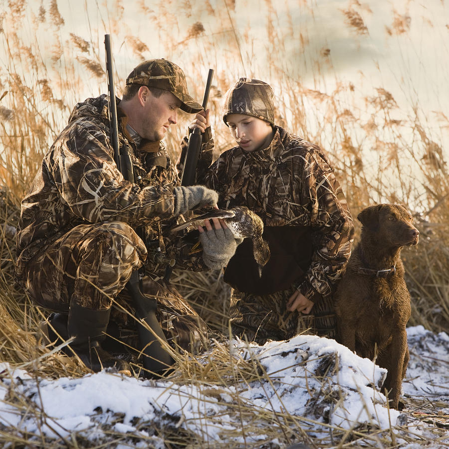 Father And Son Duck Hunting With Their Dog #2 Photograph by RubberBall Productions