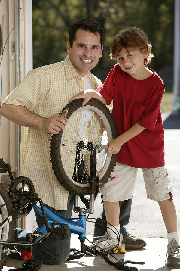 Father and son fixing bicycle #2 Photograph by Comstock Images