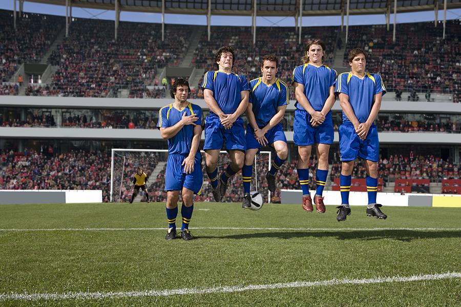 Footballers defending a free kick #2 Photograph by Image Source