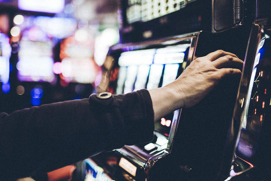 Hand of a 59 year old woman playing a slot machine in one of Las Vegas casinos. #2 Photograph by Instants