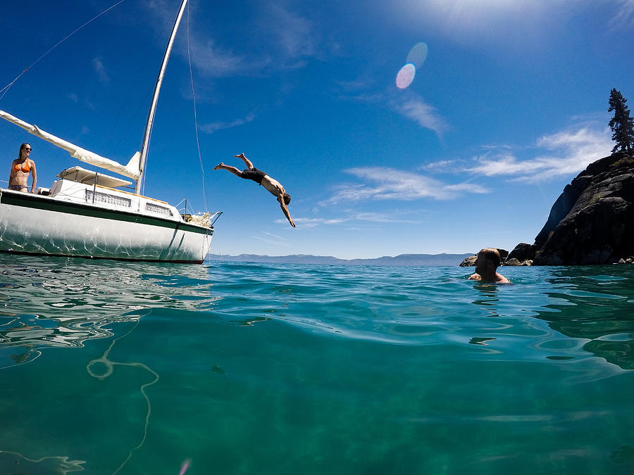 Man dives into beautiful green waters off sailboat #2 Photograph by VAWiley