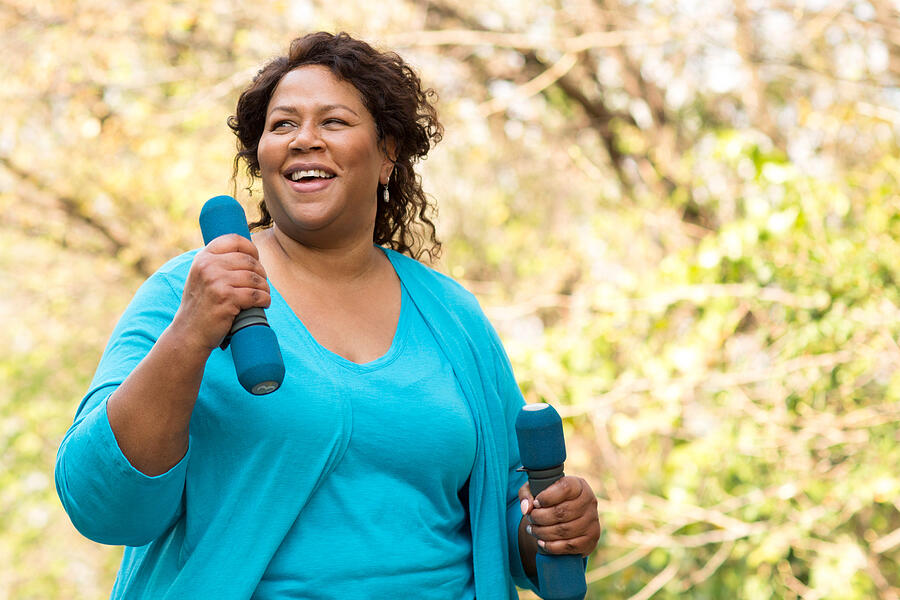 Mature African American woman smiling and exercising. #2 Photograph by Digitalskillet