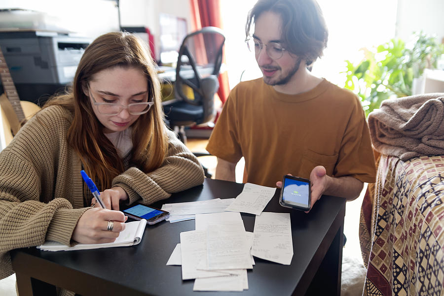 Millennial couple using digital payment to share expense. #2 Photograph by Martinedoucet