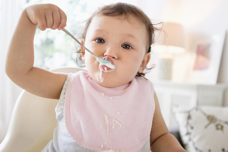 Mixed race baby girl eating yogurt #2 Photograph by JGI/Tom Grill