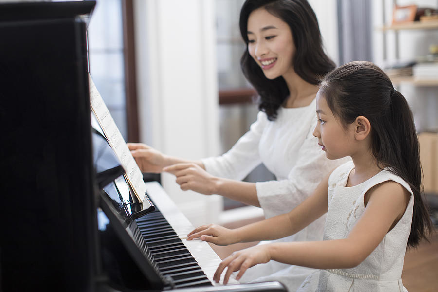Mother teaching daughter to play the piano #2 Photograph by BJI / Blue Jean Images