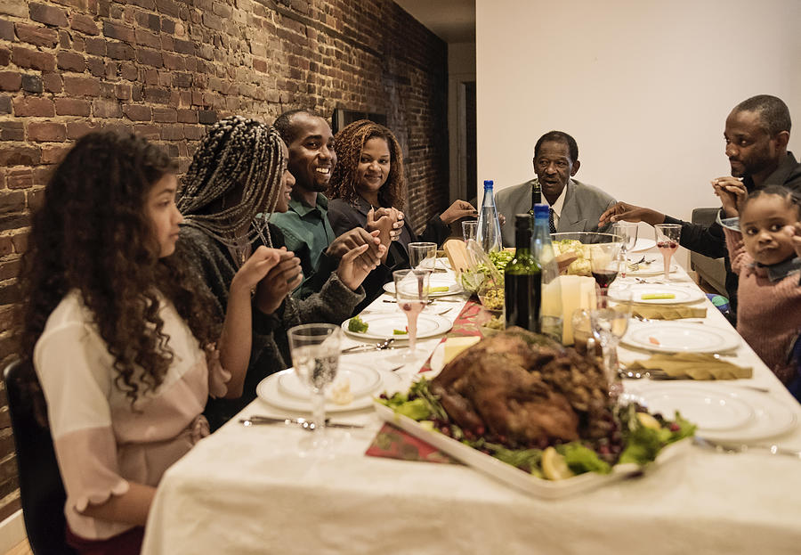 Multi-generation family saying grace for Thanksgiving dinner. #2 Photograph by Martinedoucet