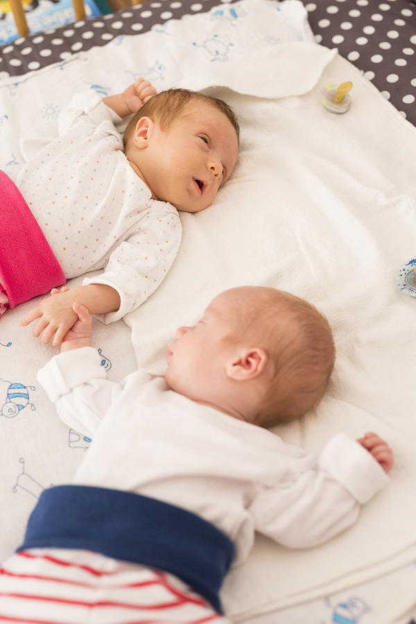 Newborn twins sleeping hand in hand #2 Photograph by Westend61