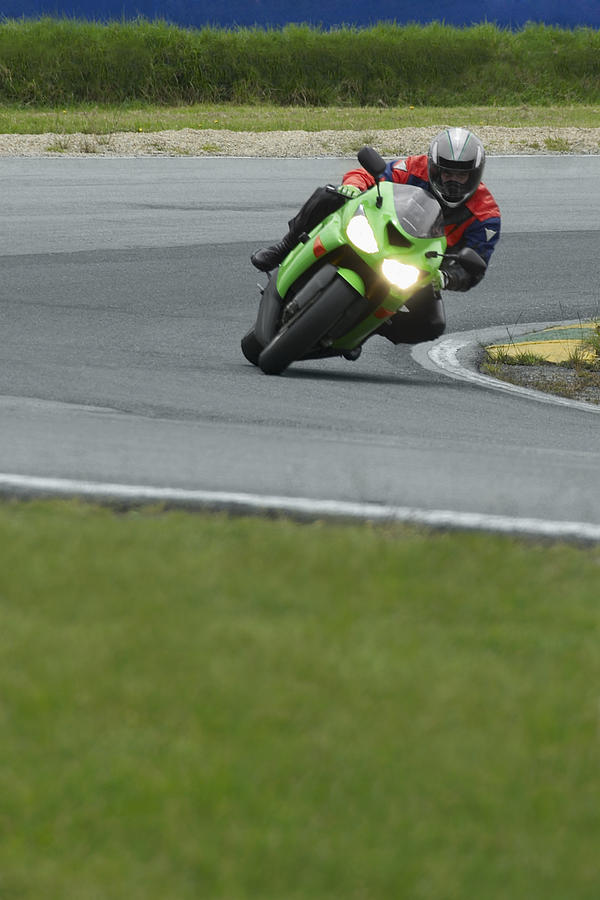 Person riding a motorcycle on a motor racing track #2 Photograph by Glowimages