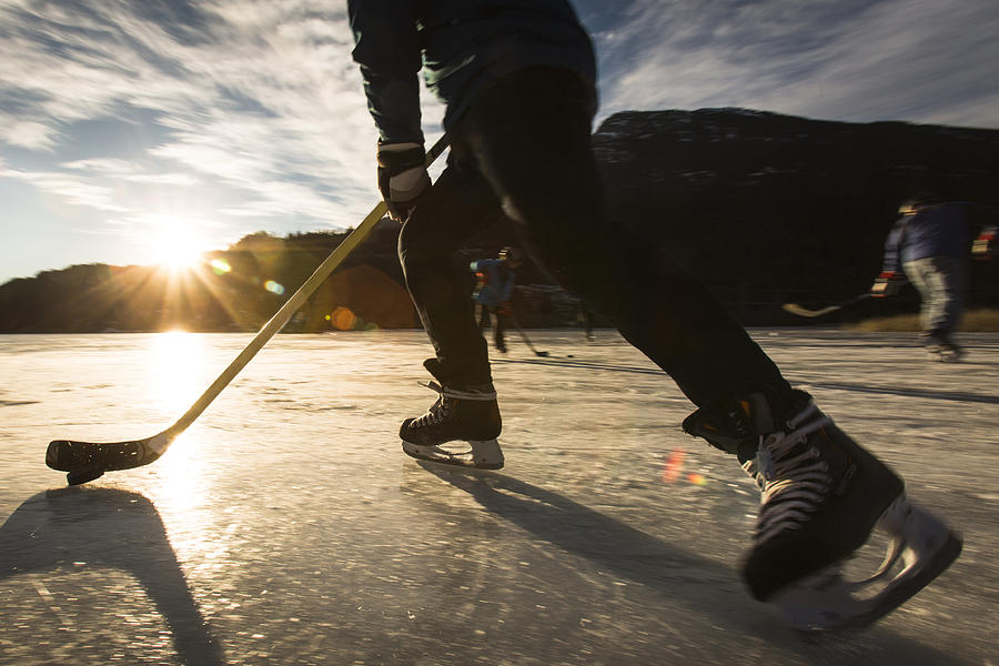 Playing ice hockey on frozen lake in sunset. #2 Photograph by VisualCommunications