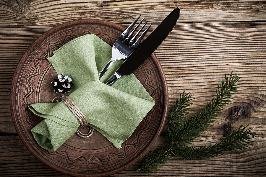 Rustic Christmas place setting,  plate, knife and fork wrapped with napkin on rustic wooden table, top view. Winter holiday theme,  Happy New Year decoration with copy space #2 Photograph by Istetiana
