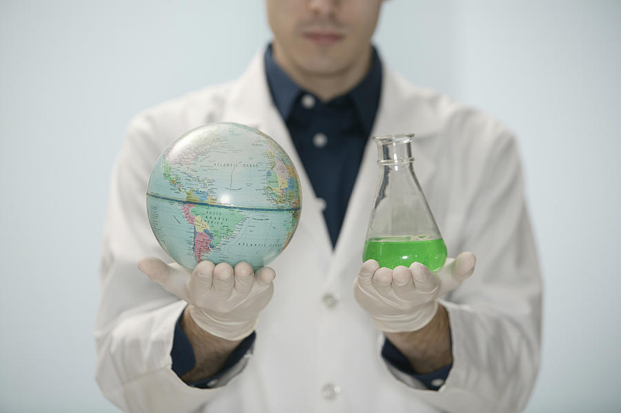 Scientist holding globe and beaker #2 Photograph by Comstock Images