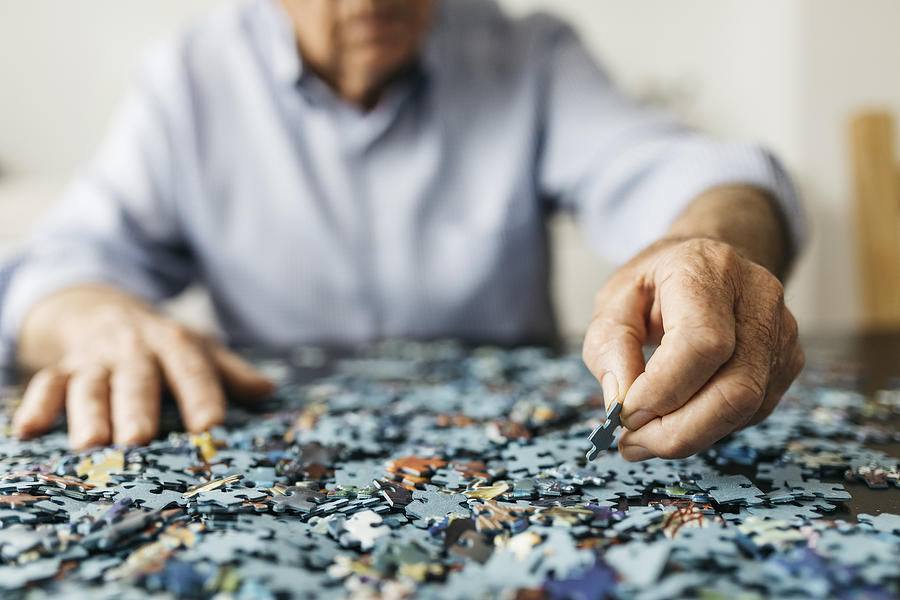 Senior man doing a jigsaw #2 Photograph by Westend61