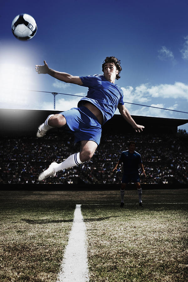 Soccer player kicking soccer ball #2 Photograph by Paul Bradbury