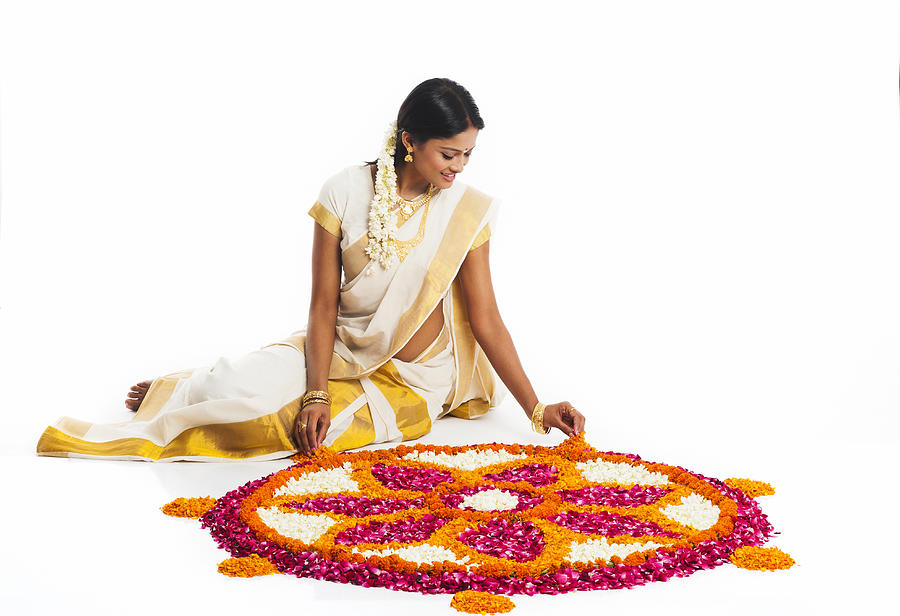 South Indian woman making a rangoli of flowers at Onam #2 Photograph by Uniquely India