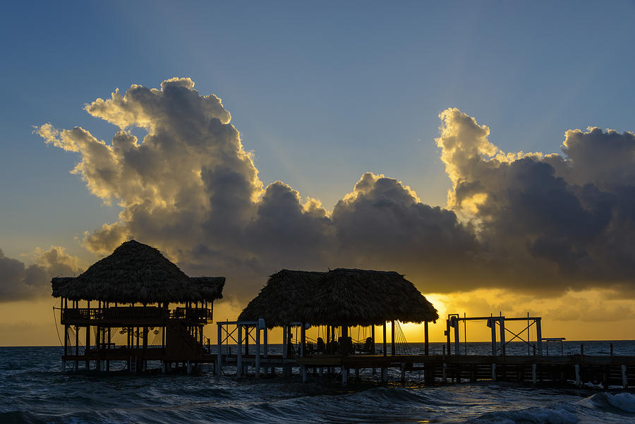 Sunrise at the beach with silhouette of pier with thatched huts #2 Photograph by OGphoto