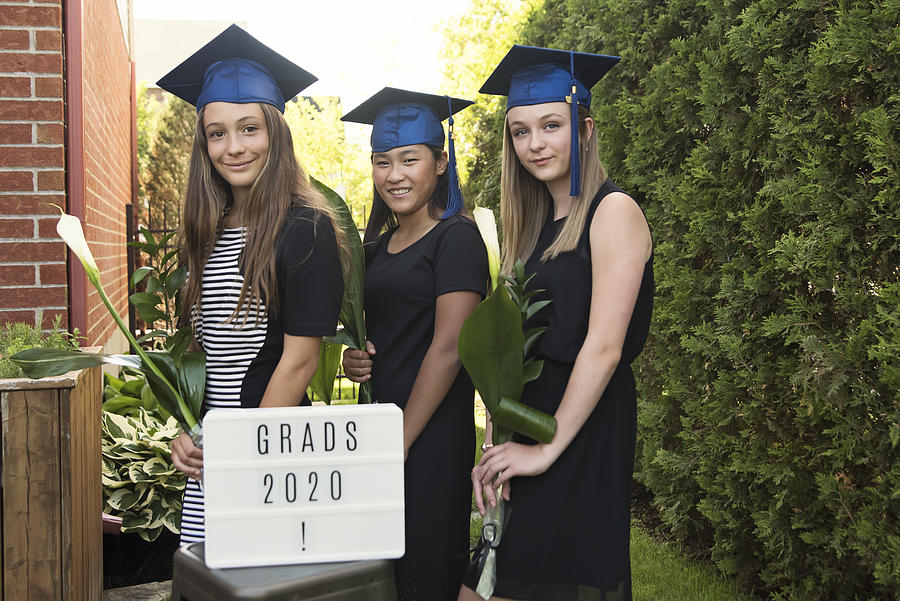 Teenage girls graduation from primary school portrait in backyard. #2 Photograph by Martinedoucet