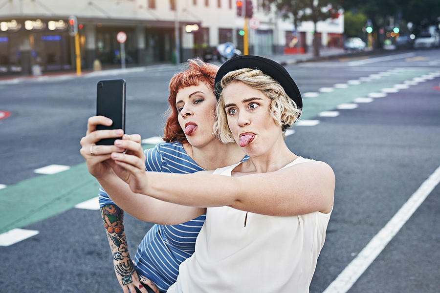 Two young women taking self portrait #2 Photograph by Uwe Krejci