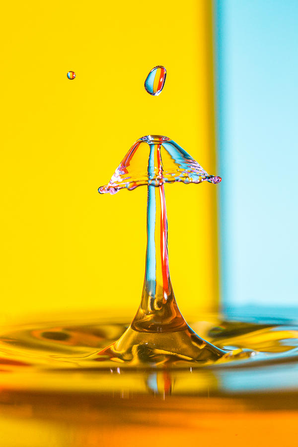Water Drip on a blue and yellow striped backdrop #2 Photograph by Robbie Goodall