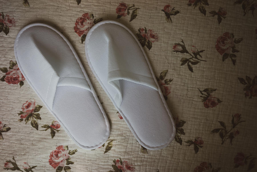 White towelling hotel disposable slippers over old and rust bed-sheet #2 Photograph by Shaifulzamri