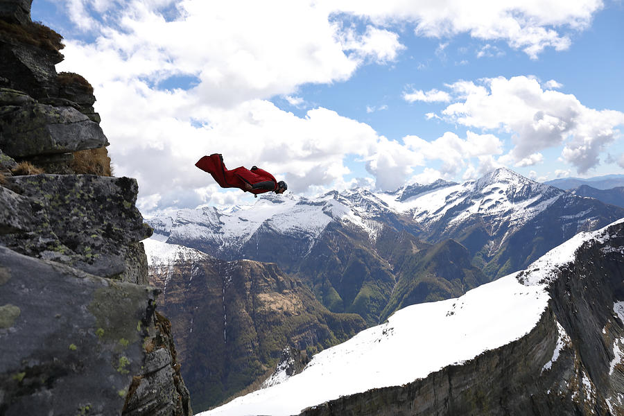 Wingsuit flyer jumps from cliff edge, mountains #2 Photograph by Ascent/PKS Media Inc.
