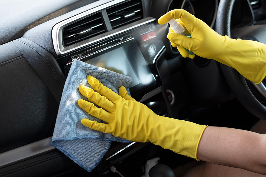 Wiping down surface of car dashboard with 70% alcohol spray and disposable damp cloth #2 Photograph by Natthawat