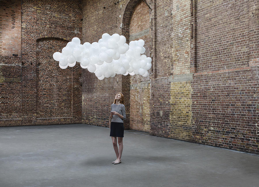 Woman in warehouse, cloud of balloons above head #2 Photograph by Anthony Harvie