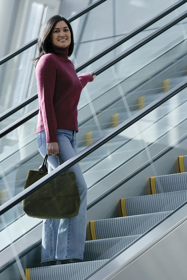 Woman on escalator #2 Photograph by Comstock Images