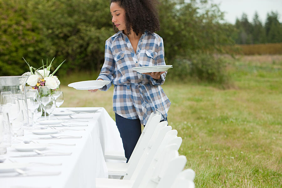 Woman preparing table for dinner party in a field #2 Photograph by Image Source